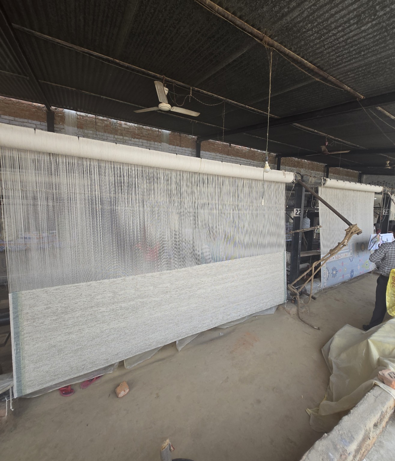 Rugs in progress on looms inside the workshop.